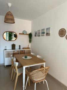 a dining room with a wooden table and chairs at Ático horizonte in Sanlúcar de Barrameda +3 photos