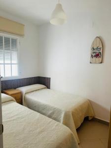 a bedroom with two beds and a mirror on the wall at Ático horizonte in Sanlúcar de Barrameda