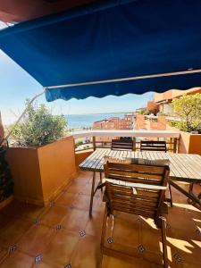 a patio with tables and chairs and a view of the ocean at Ático horizonte in Sanlúcar de Barrameda