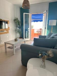 a living room with a blue couch and a table at Ático horizonte in Sanlúcar de Barrameda