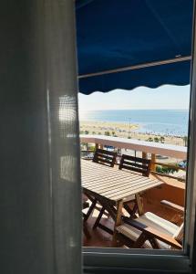 a table and chairs on a balcony with the beach at Ático horizonte in Sanlúcar de Barrameda