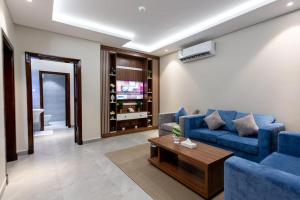 アブハにあるحياة ريزيدنسの青いソファとテーブルのあるリビングルーム