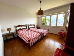 una camera con due letti con lenzuola a righe rosse e bianche di The Lemon Trees House a Lugano
