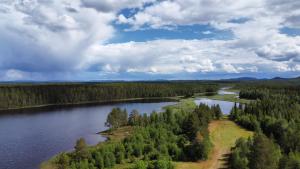 an aerial view of a lake with trees and clouds at Room Sebi in Arvidsjaur