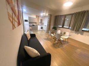 a living room with a black couch and a table at Palazzo Tondo Apartment in Oristano