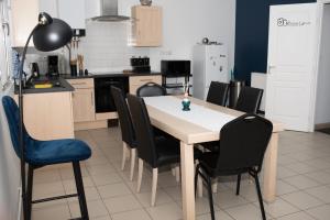 a kitchen with a table and black chairs at Appartement au rez-de-chaussée Nichée en plein centre d'Arras in Arras
