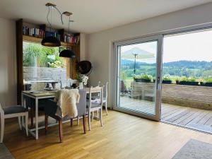 a dining room with a table and a sliding glass door at ALPEN WOHLFÜHLQUARTIER in Bad Bayersoien
