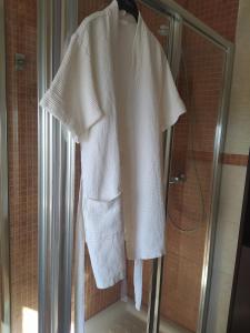 a white robe is hanging in a shower at Adosado en La Bahía de Casares in Bahia de Casares