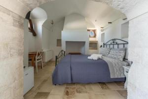 a bedroom with a bed and a table and a kitchen at Donna Teresa in Mottola