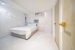 a white bedroom with a bed and a door at Surf Beach House Pool Villa in Na Jomtien +38 photos