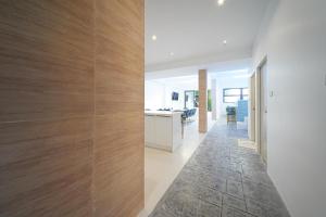 a hallway of a house with wooden walls and a kitchen at Surf Beach House Pool Villa in Na Jomtien