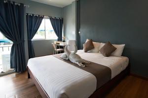 a bedroom with a bed with a cat sitting on it at A Hotel Cozy in Ban Pa Sak