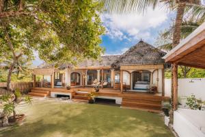 an exterior view of a house with a yard at Kubu Pantai - Bela Sulu Villas in Katiet