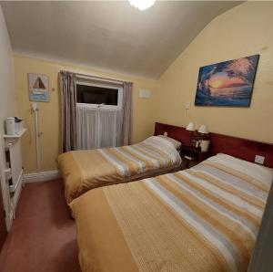 a hotel room with two beds and a window at THE ROCK n ROLL in Blackpool