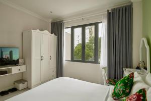 a bedroom with a white bed and a window at Chez Mimosa - Free Laundry in Ho Chi Minh City