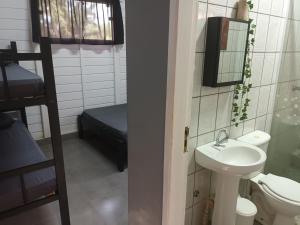 a bathroom with a sink and a toilet and a mirror at Chalés Cambury in Camburi