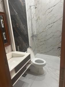 a bathroom with a toilet and a sink and a tub at Doctor's house in Lahore +4 photos