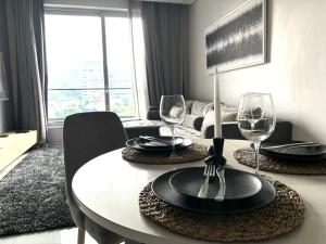 une table de salle à manger avec des verres à vin dessus dans l'établissement The Capital in Sandton-Luxury aparthotel, à Johannesbourg
