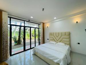 Un dormitorio con una cama grande y una ventana grande. en The Silent Gate, en Ipitagoda