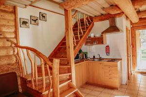 a kitchen with a spiral staircase in a log cabin at Atpūtas komplekss ''Lācītes'' in Gulbene