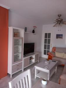 a living room with a couch and a table at Chalet adosado con piscina in Caleta De Velez