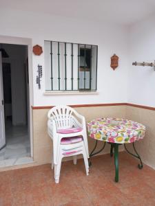 a table and a chair and a bench on a porch at Chalet adosado con piscina in Caleta De Velez