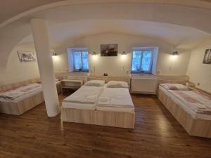 una camera con tre letti e due finestre di Apartmány pod Klášterem a Kladruby