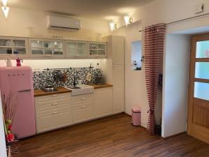 eine Küche mit weißen Schränken und einem rosa Kühlschrank in der Unterkunft City Apartment Skradin National Park Krka Wasserfälle in Skradin
