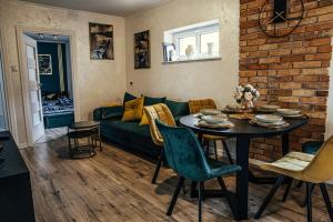 a living room with a green couch and a table at Apartament Good Time Starówka in Elblag