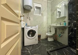 a bathroom with a washing machine and a sink at Apartmani Suvodoli in Rvaši +56 photos