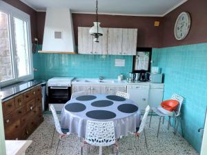 une cuisine avec une table et des chaises dans l'établissement Parenthèse Océane Suite calme 1 ou 2 chambres entre bois et mer, à Perros-Guirec