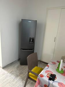 a kitchen with a refrigerator and a table and a chair at Hegla diamant naima in Harqalah