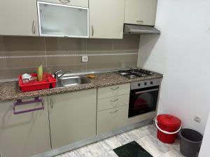 a small kitchen with a sink and a stove at Hegla diamant naima in Harqalah