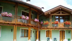 zielony dom z skrzyniami kwiatowymi na balkonach w obiekcie Residence Il Giardino w mieście Croviana