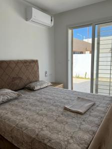 a bedroom with a large bed with a large window at Villa ALKANTARA - 4 Bedroom in Ouled Yaneg
