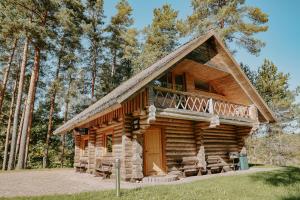 a log cabin with a porch and a balcony at Atpūtas komplekss ''Lācītes'' in Gulbene