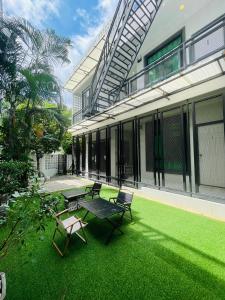 清迈Sky View Home and Hostel Chiangmai的草坪上带桌椅的天井。