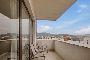 a balcony with chairs and a view of the city at ArtMob Apartment Isaran in Braşov