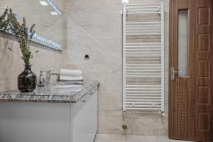 a white bathroom with a sink and a shower at ArtMob Apartment Isaran in Braşov +22 photos