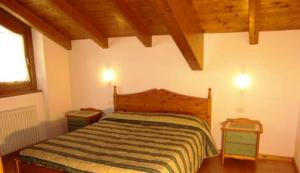 a bedroom with a bed and two night stands at Residence Il Giardino in Croviana