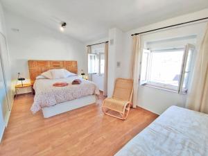 a bedroom with a bed and a chair and a window at Casa Cerro Luna in Constantina