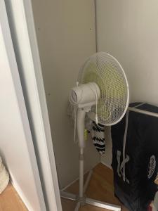 a white fan in a corner of a room at Duplex cosy bord de Mer in Saint-Cyr-sur-Mer