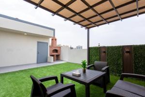 a patio with a table and chairs on a lawn at منتجع حياة ريزيدنس in Abha