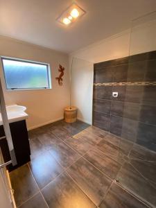 a bathroom with a shower and a tiled floor at The King's Keep in Cable Bay +24 photos