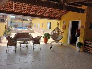 a patio with a table and chairs and a cat on a patio at 600 metros da praia piscina e churras 3 vagas in Mongaguá