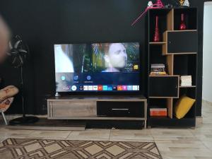 a flat screen tv sitting on a entertainment center at 600 metros da praia piscina e churras 3 vagas in Mongaguá