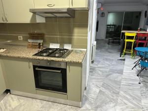 a kitchen with a stove and a counter top at Diamant Sahbi in Harqalah