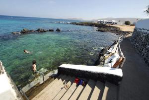 Ein Mann, der auf einem Boot im Wasser schwimmt. in der Unterkunft Punta mujeres casitas del mar in Arrieta