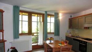 a kitchen with green curtains and a table in it at Residence Il Giardino in Croviana
