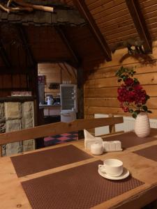 a wooden table with a vase of flowers on it at Vodoliy in Mykulychyn
